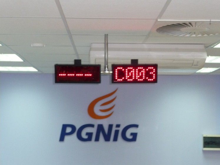 Wyświetlacze stanowiskowe LED nad ścianą z logo PGNiG – biuro obsługi klienta we Wrocławiu