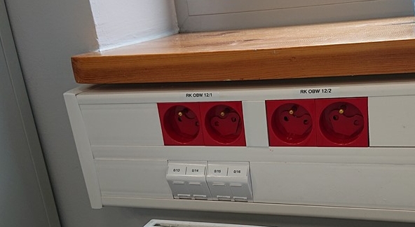 Gniazda zasilania dedykowanego i gniazda RJ45 w kanale pod blatem – strefa obsługi interesantów NFZ w Poznaniu